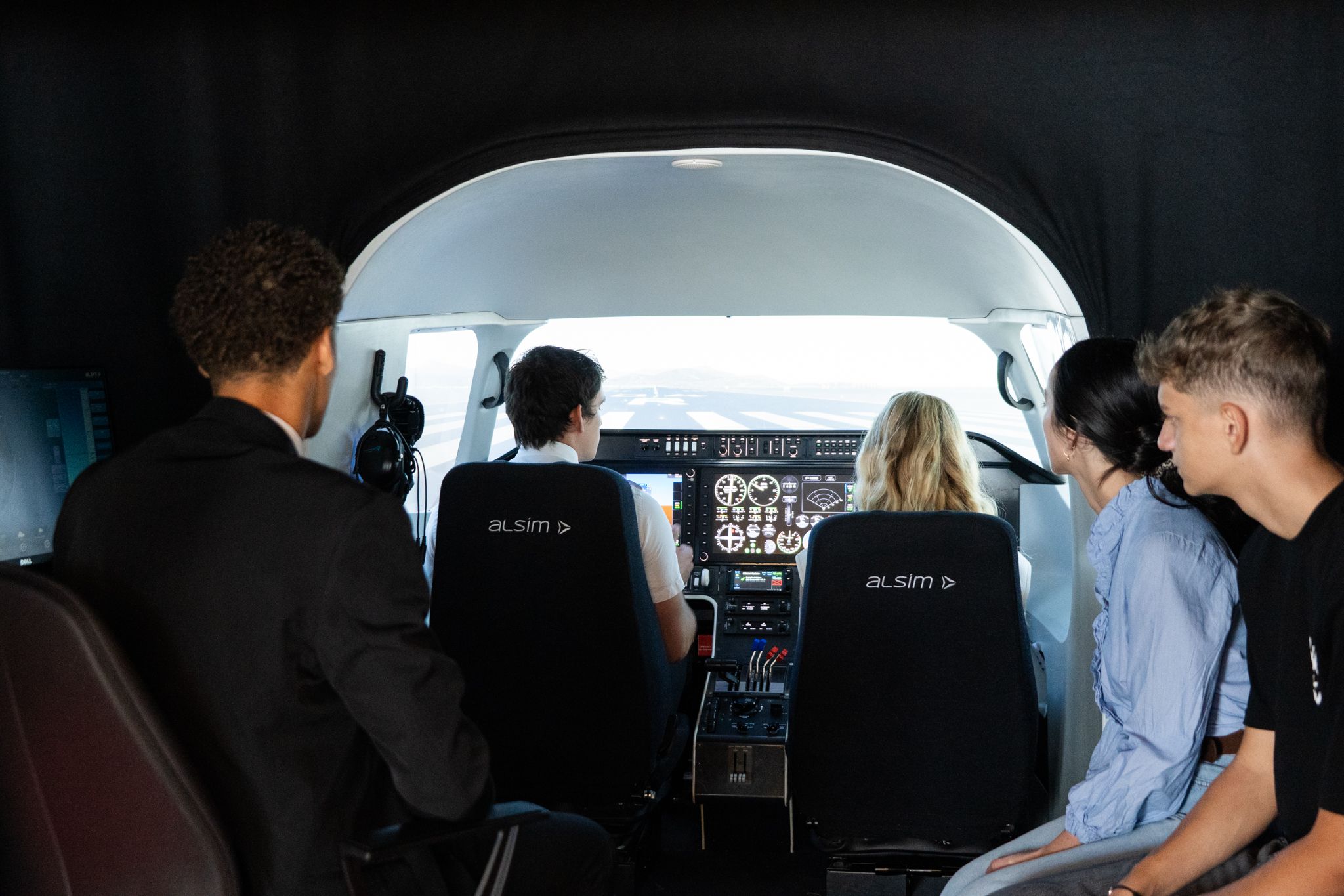 Élèves pilotes découvrant un simulateur de vol Alsim sur le campus Astonfly