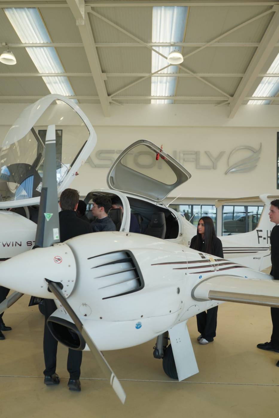 Élèves pilotes Astonfly devant un avion école dans le hangar de Toussus-le-Noble